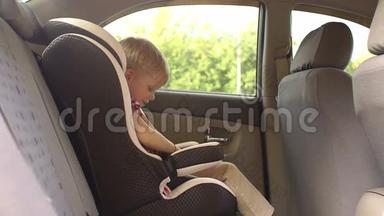 一个小男孩在车里的儿童汽车座椅上解开安全带。